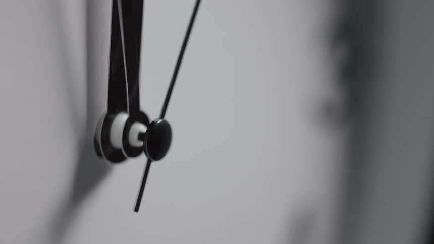 Extreme closeup of a secondhand moving on a plain wall clock
