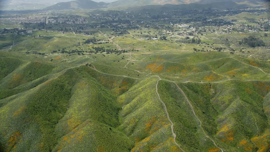 The hills below are surrounded by water and green