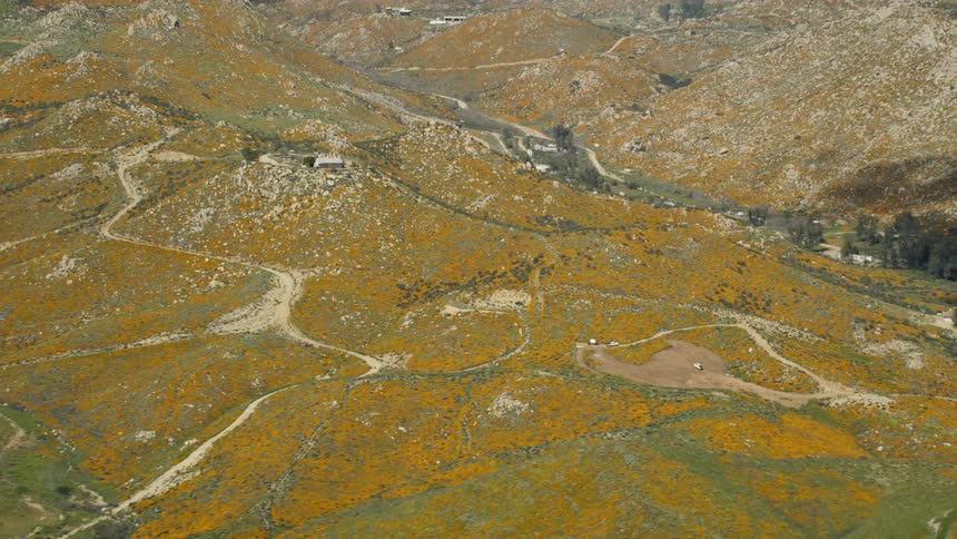 The long row of hills are green with some camps set up in spots