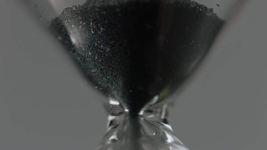 Sand falls in an hourglass