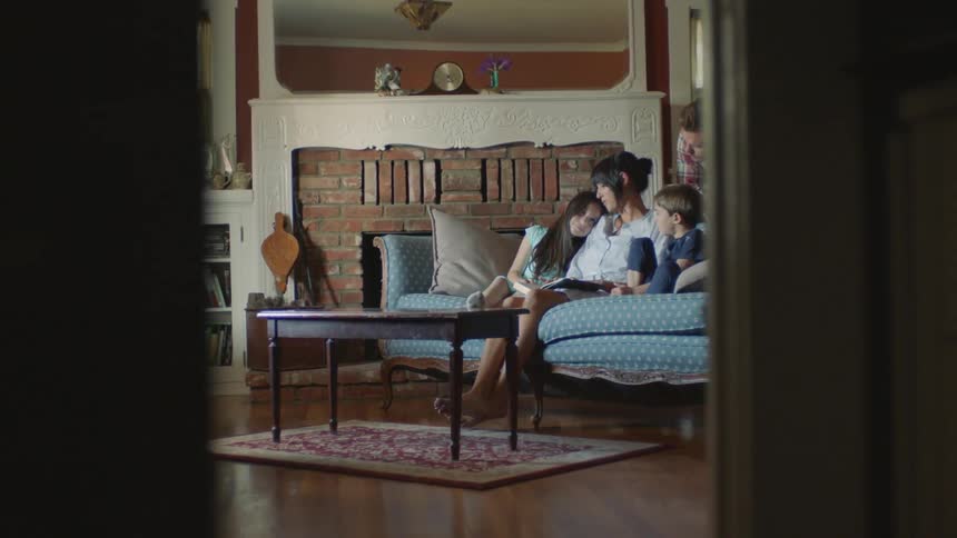 Family sits on the sofa and talk together