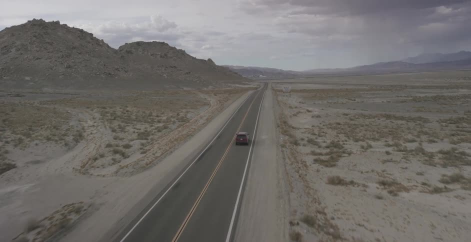 Vehicle drives down an empty road on a cloudy day