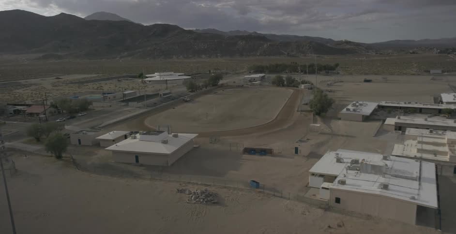 Aerial view of some buildings and a field on a cloudy day