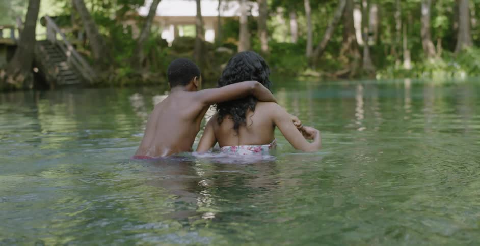 A woman and teenage boy swim in a lake