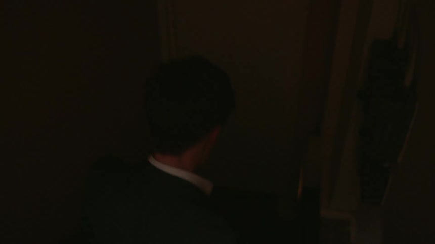 A man is walking down a stairwell into a bar at night