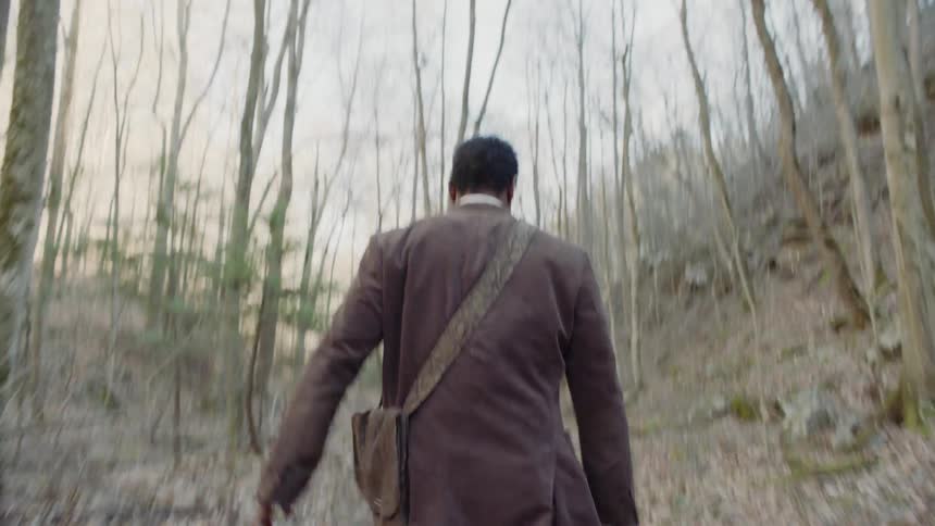 A man is taking a sword from a dead union soldier and pursuing a confederate with it in daylight