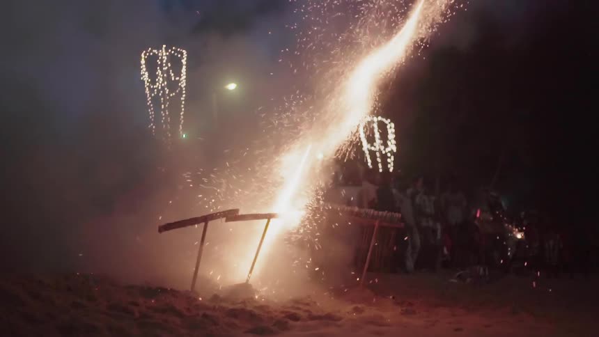 People are standing around outside lighting off fireworks