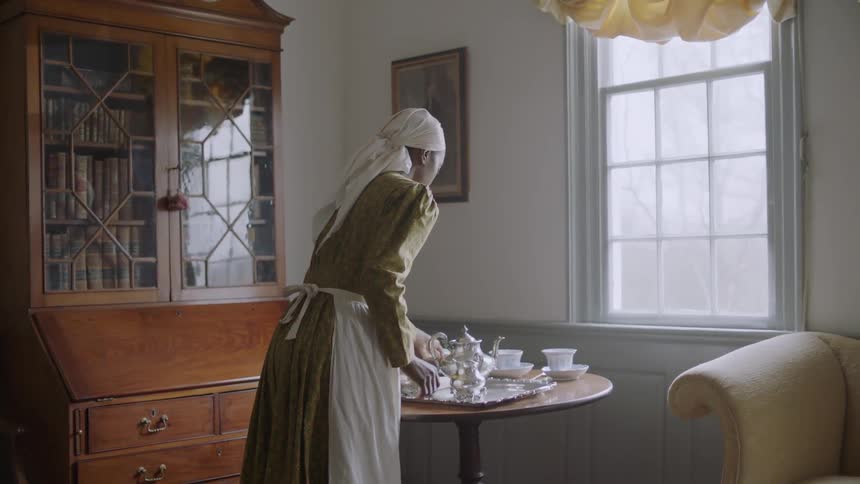 A servant serves tea on a tray