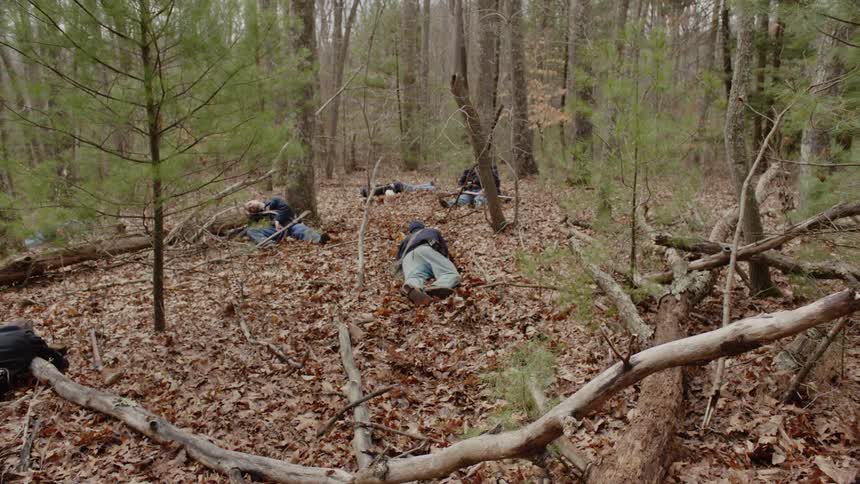 Soldier lying and crawling in the woods