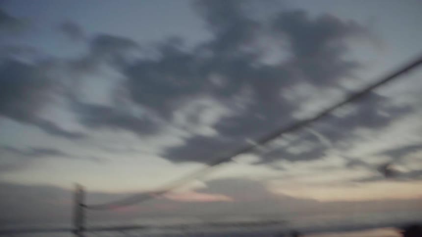 Volleyball flies back and forth over a net on the beach at sunset
