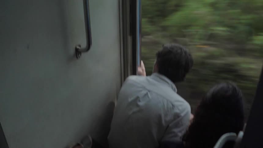 Man and woman riding on a vehicle looking out the window