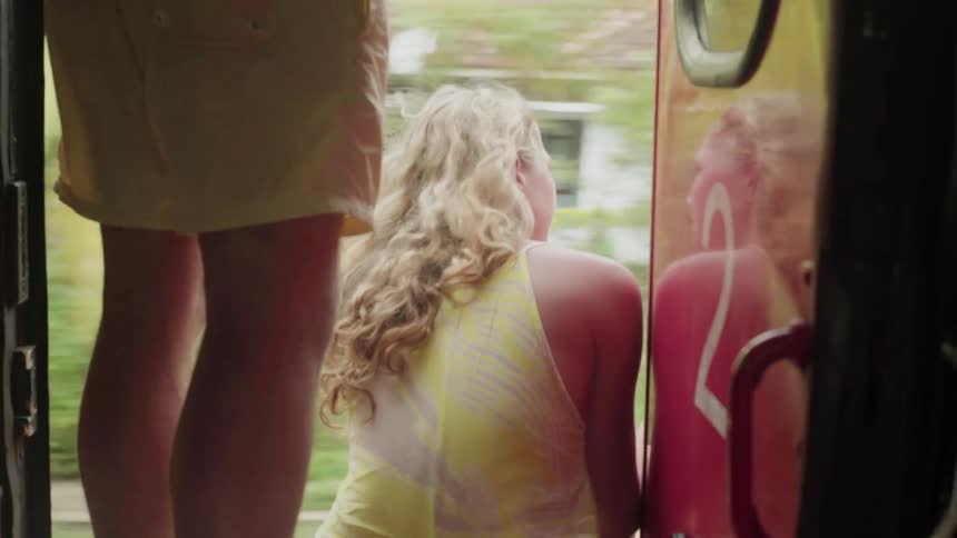 Woman riding a train, sits in the doorway