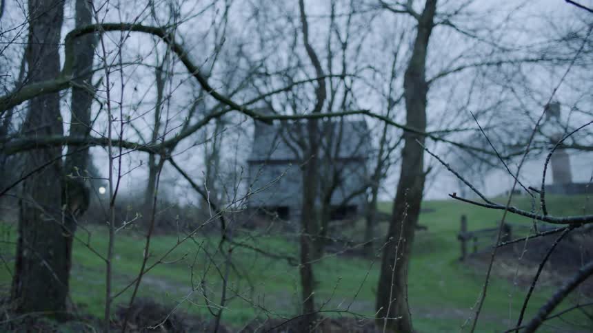 A house sits atop a hill on an overcast day