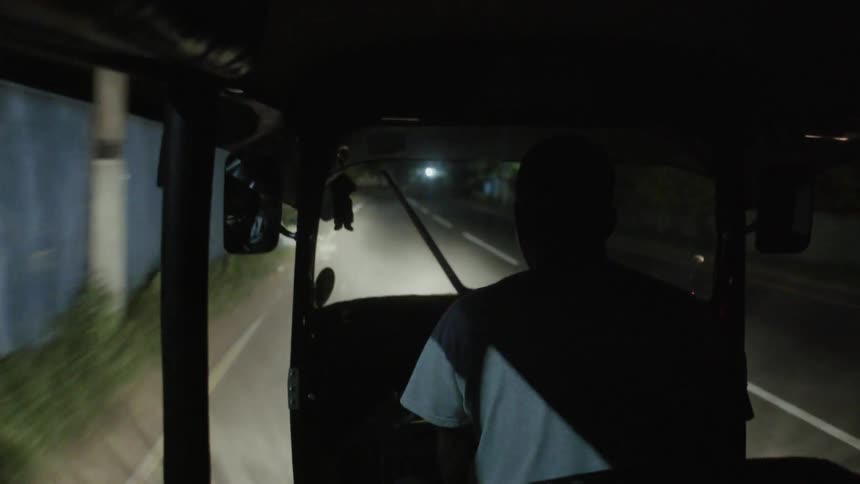 Vehicle travels down a country road at night