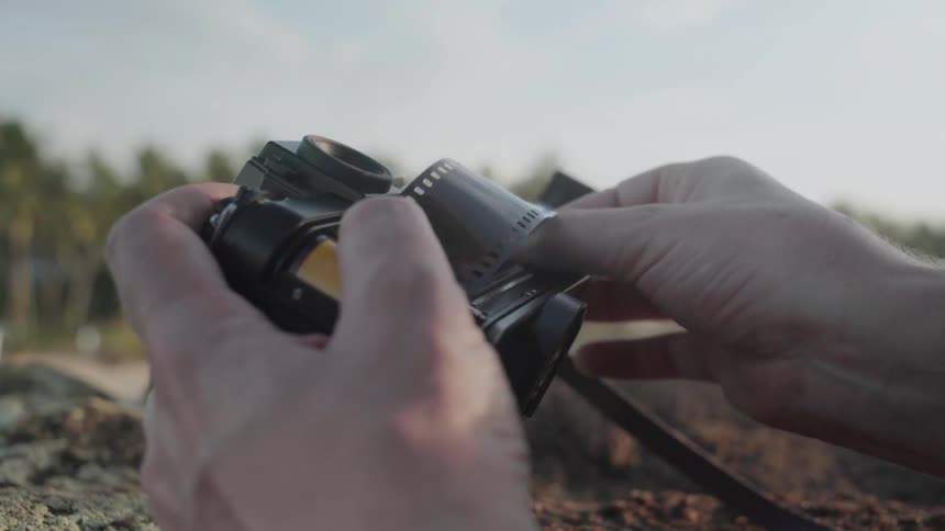 Person's hands as they try to put film in a camera