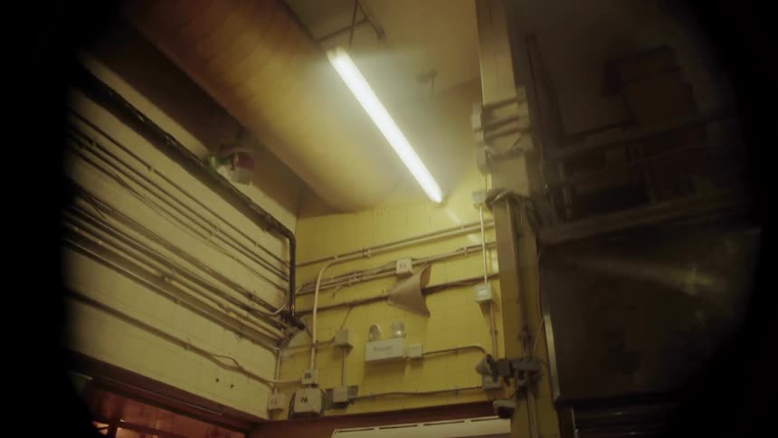 A ceiling fan is spinning inside a building at night