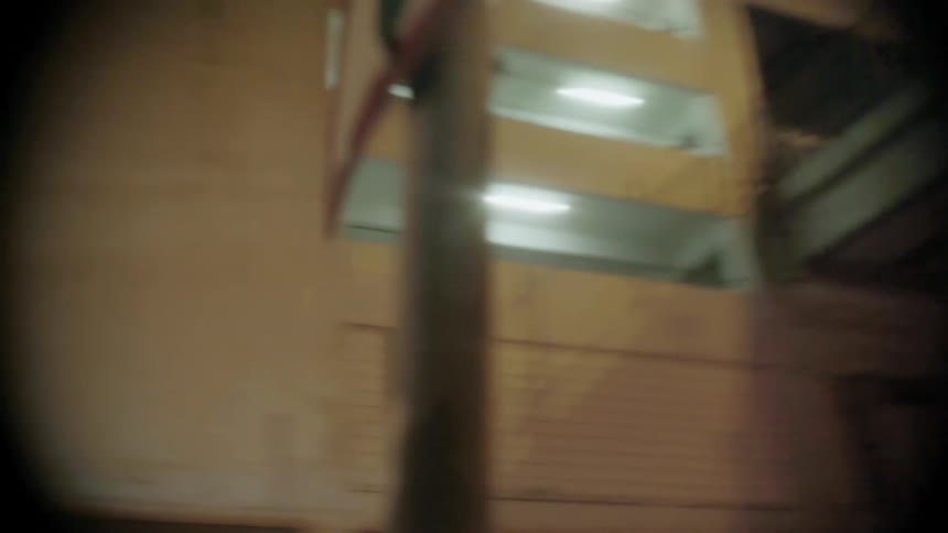 A vehicle is driving into a garage outside in a city at night