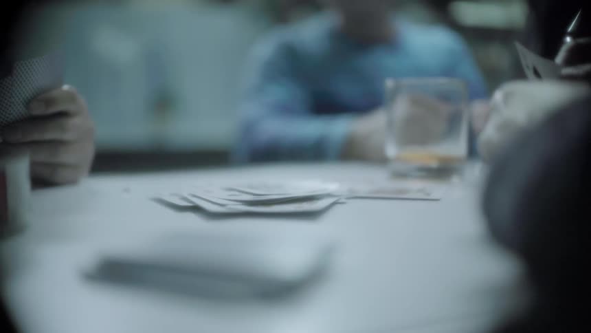 A group of people play cards together