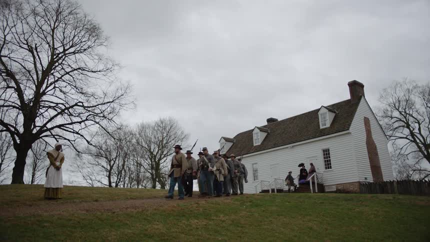 Confederate soldiers are marching away from a home on a cloudy day