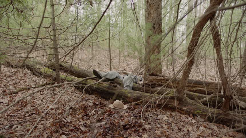 Soldier lies across logs as if dead