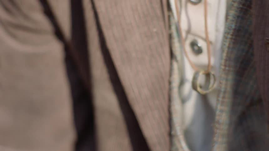 A man wears rings on a necklace