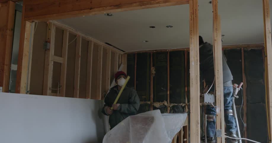 Construction workers work inside a house