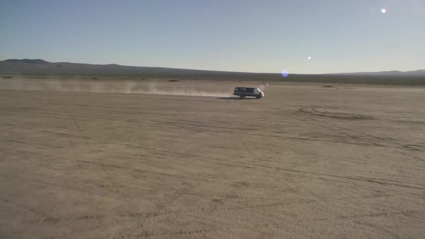 A truck is driving across a desert