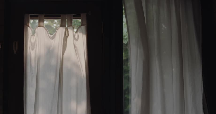 Wind blowing some curtains gently on an open window