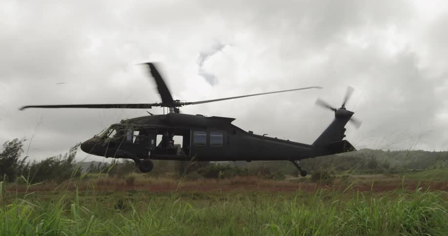 A large helicopter takes off in a cloudy sky