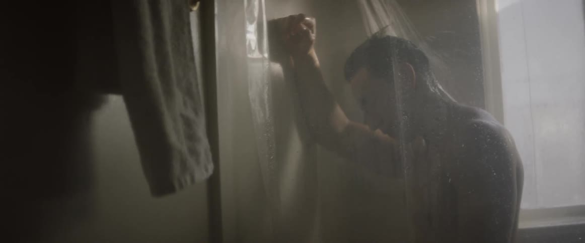A man leans forward in the shower