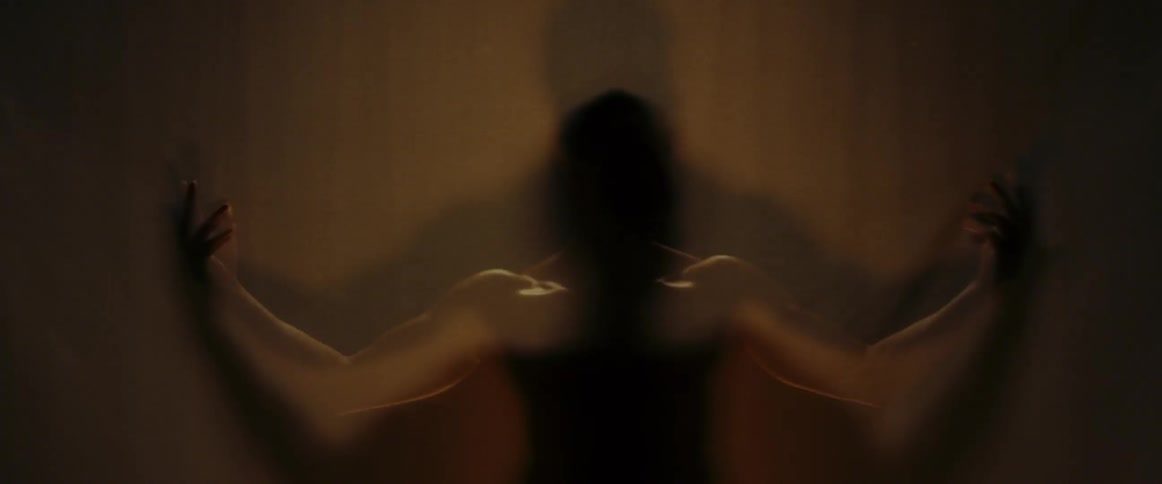 A shirtless man raises his arms