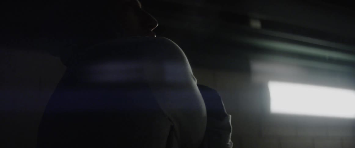 Man stretches in a dark basement