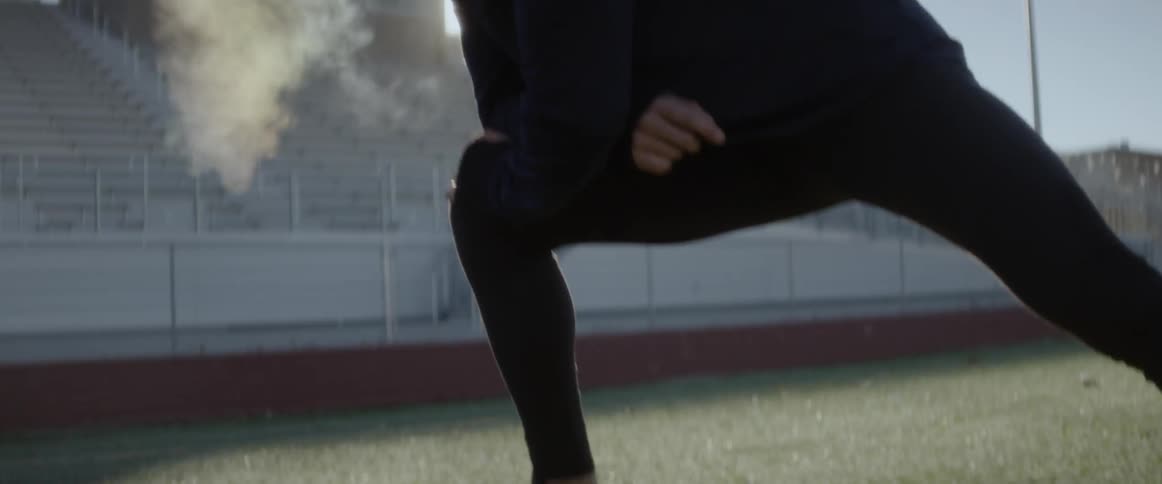 A man stretches on the sports field