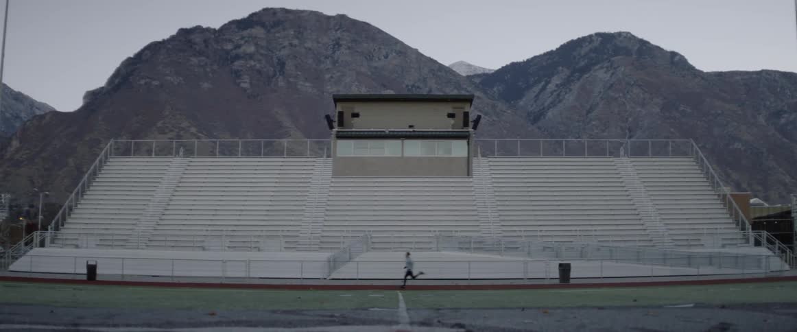 A man runs past the bleachers of the field