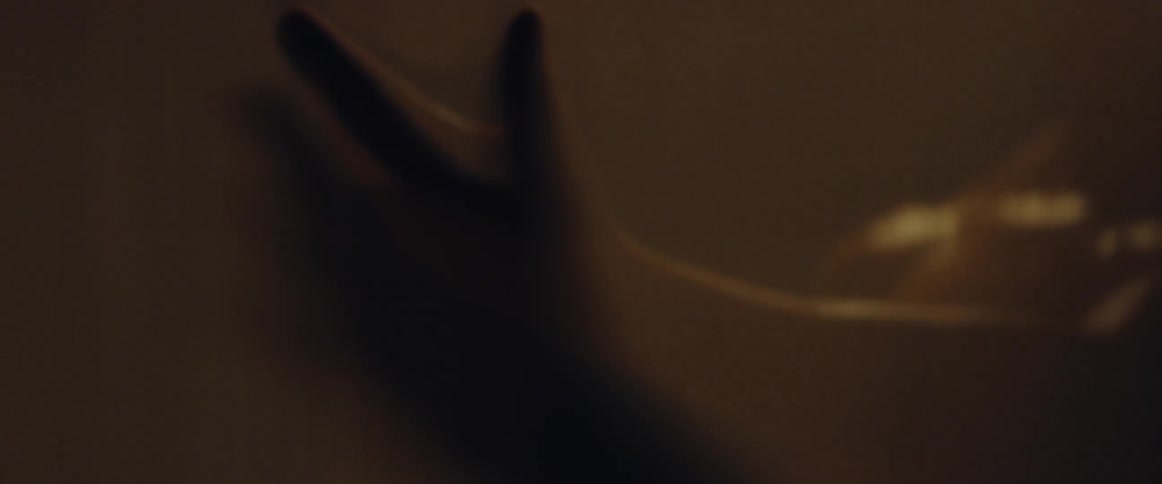 Person moving their hand around in dimly lit room