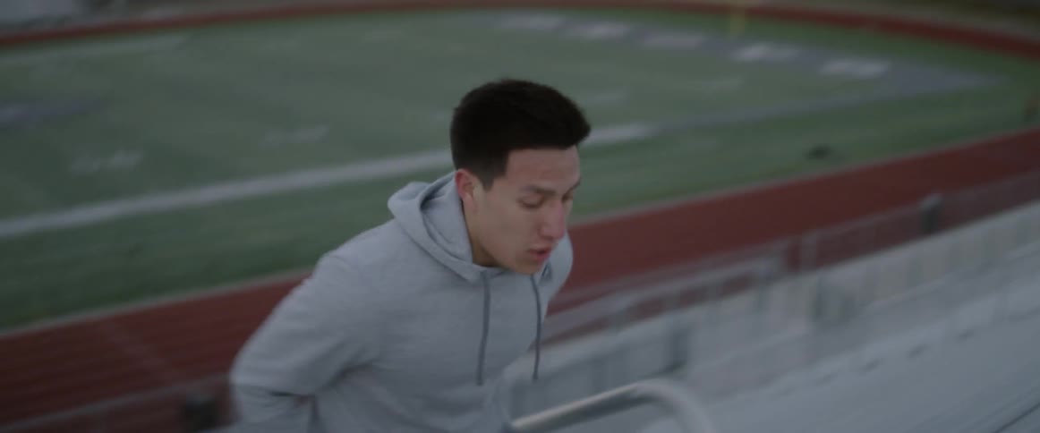 A man sprints up outdoor bleachers