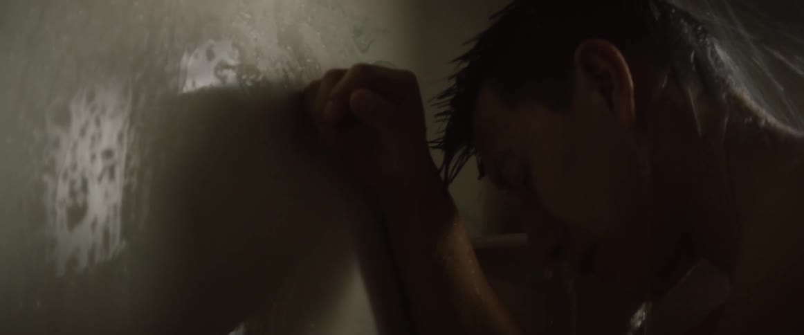 Man leans against the wall while showering