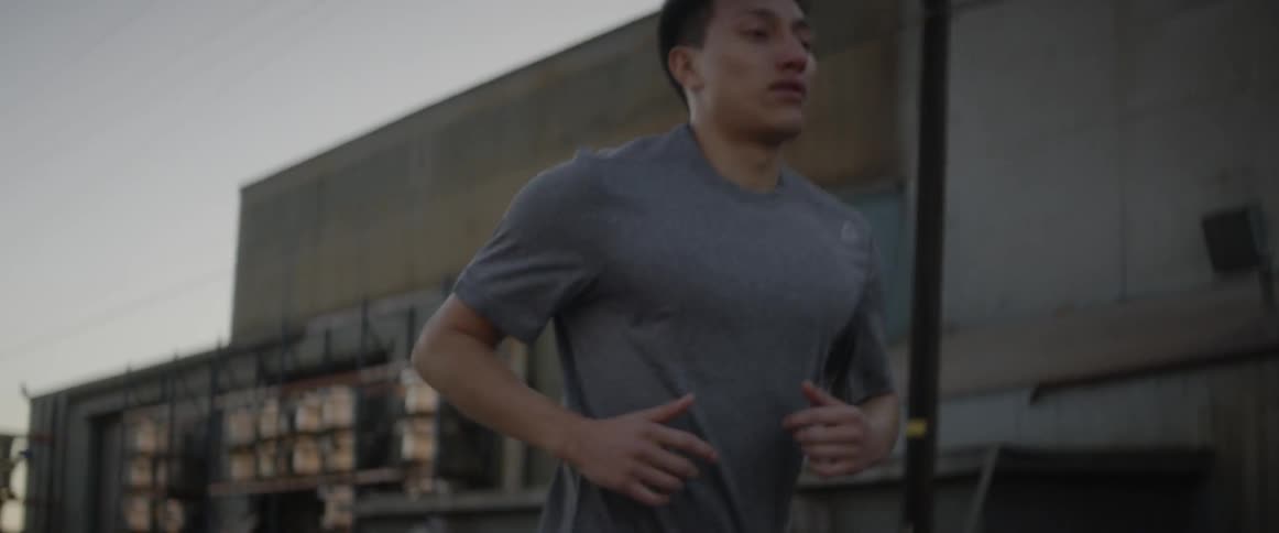 Man jogging on a city street on a cloudy day