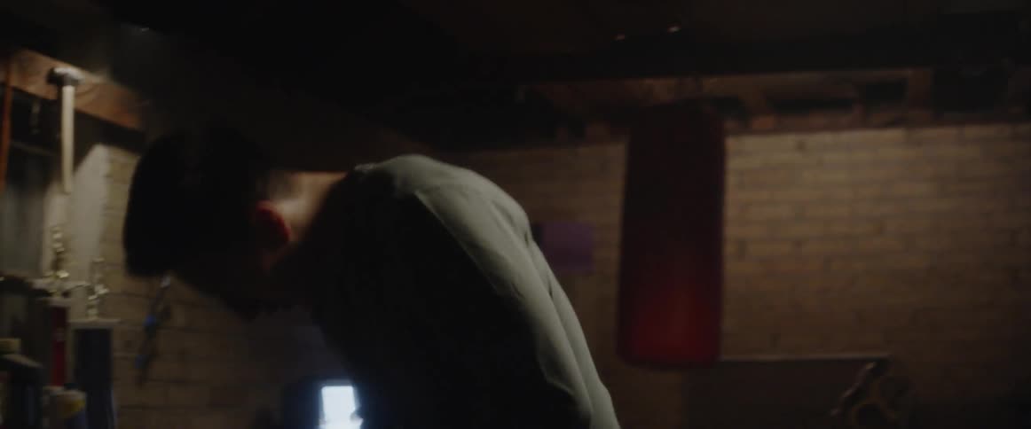 Man in boxing gym stands up and reaches for water