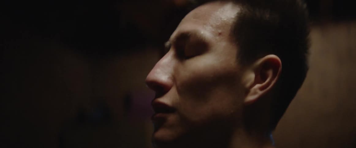 A man is looking around in the dark room