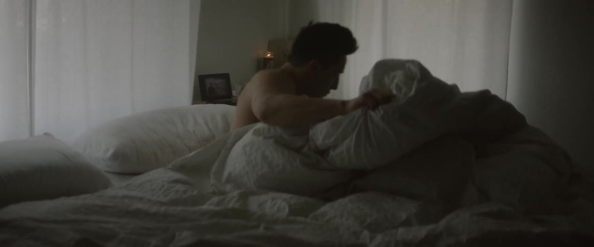 Man wakes up and sits on edge of his bed