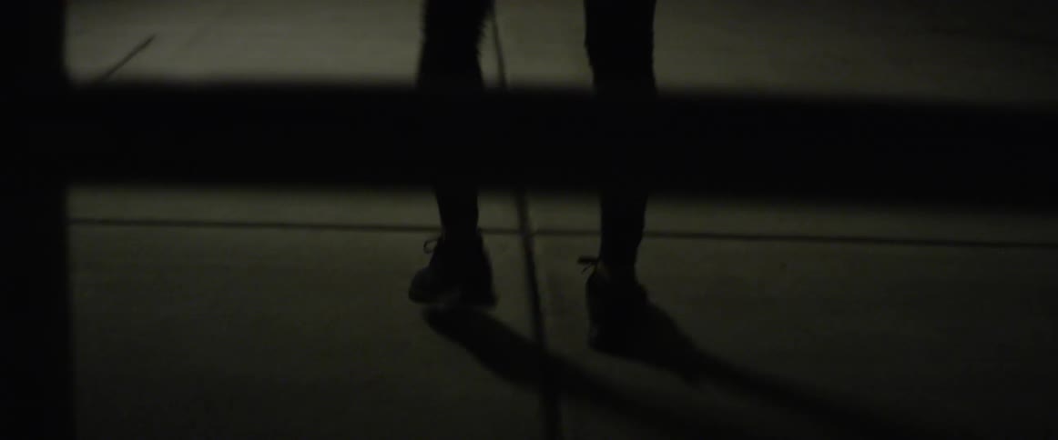 Man stretches his legs as he stands in a large building