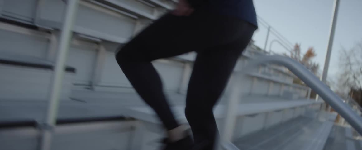 A man runs up the bleacher steps