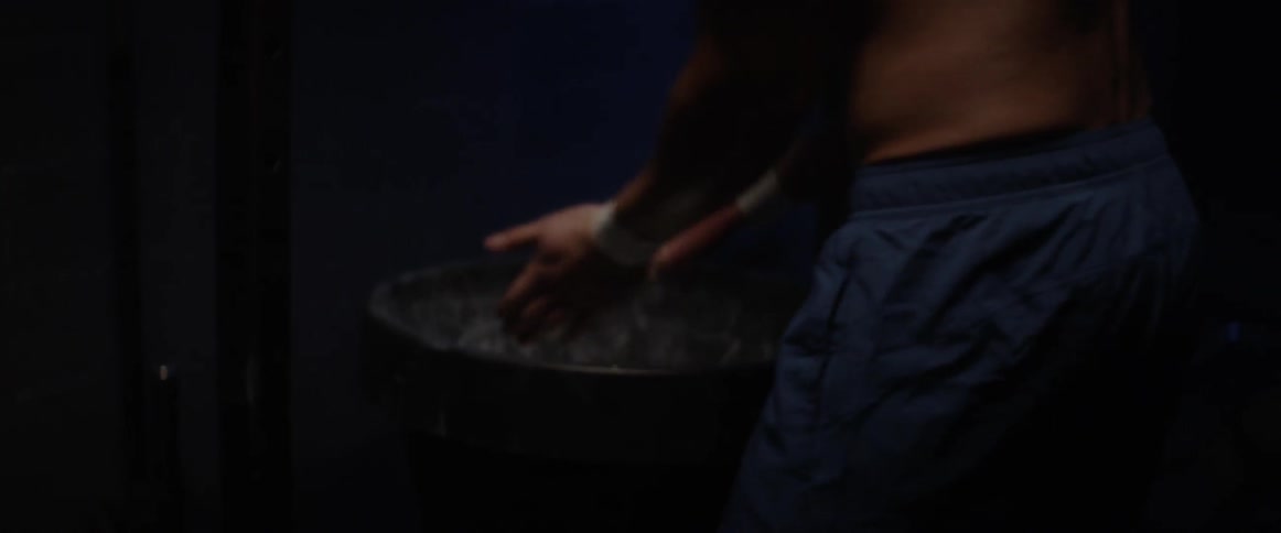 An athlete wraps his wrists in a locker room