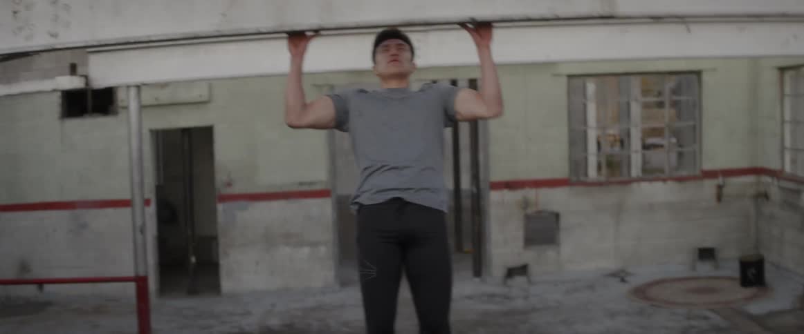 Man does pull ups using a concrete beam