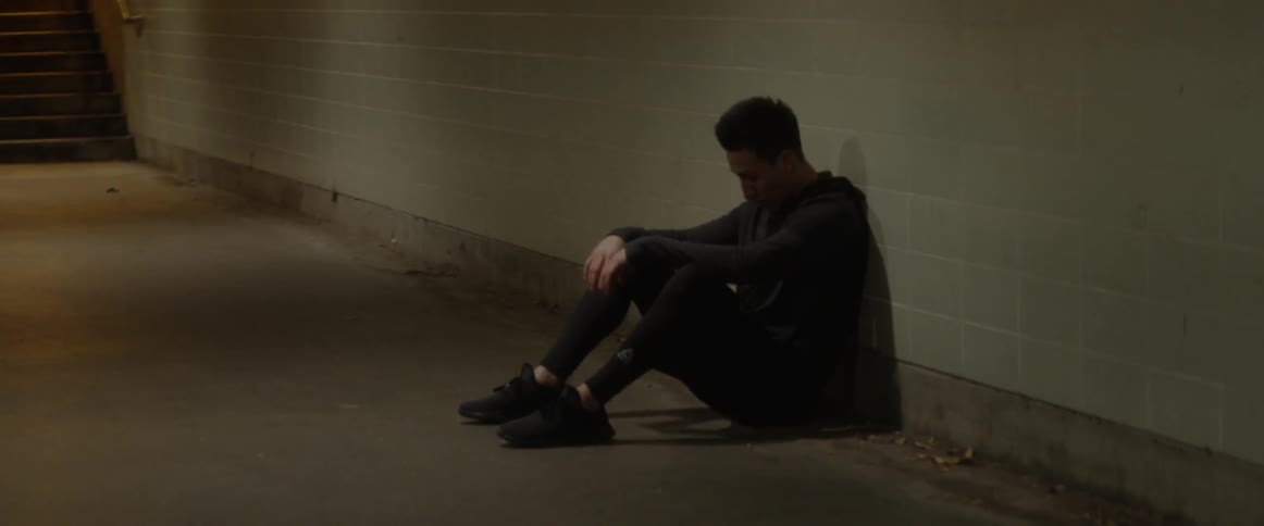 Man sits and leans against a wall