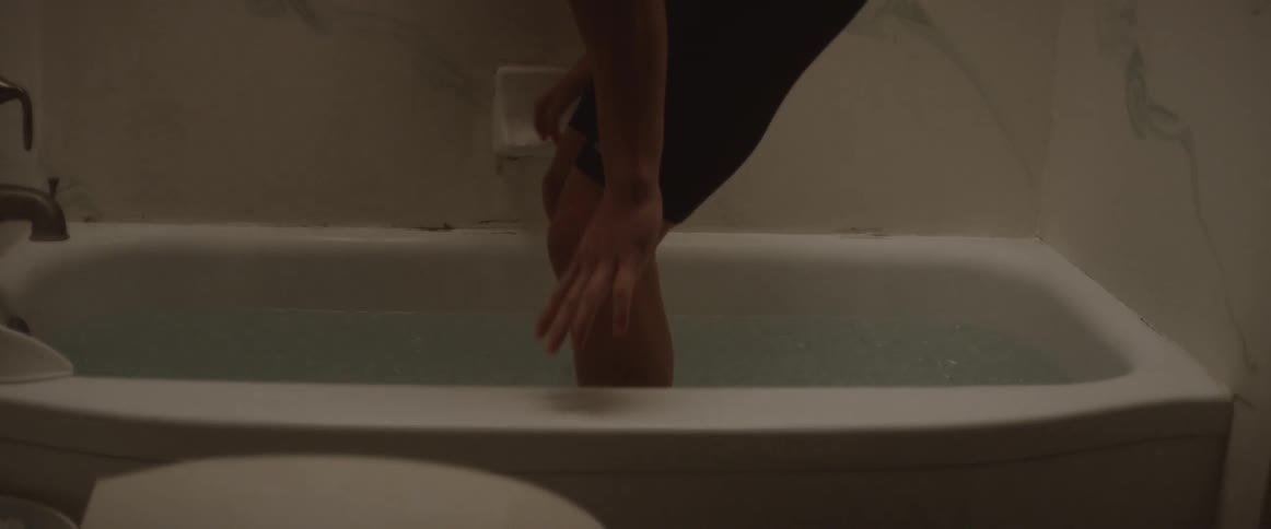 Man climbs into a bathtub with ice water