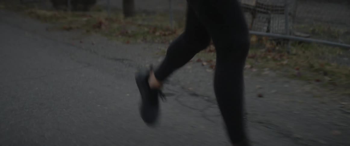A person is jogging outside in a rural area at dusk