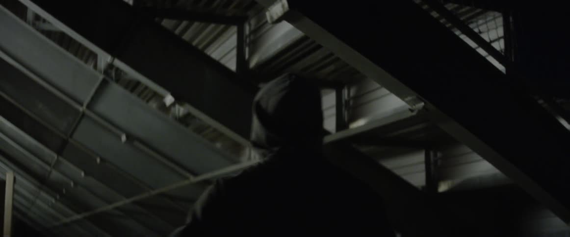 A man stretches out his legs in the dark hall