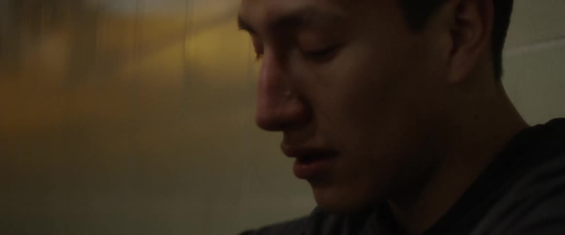 A man leans against the wall looking up and down